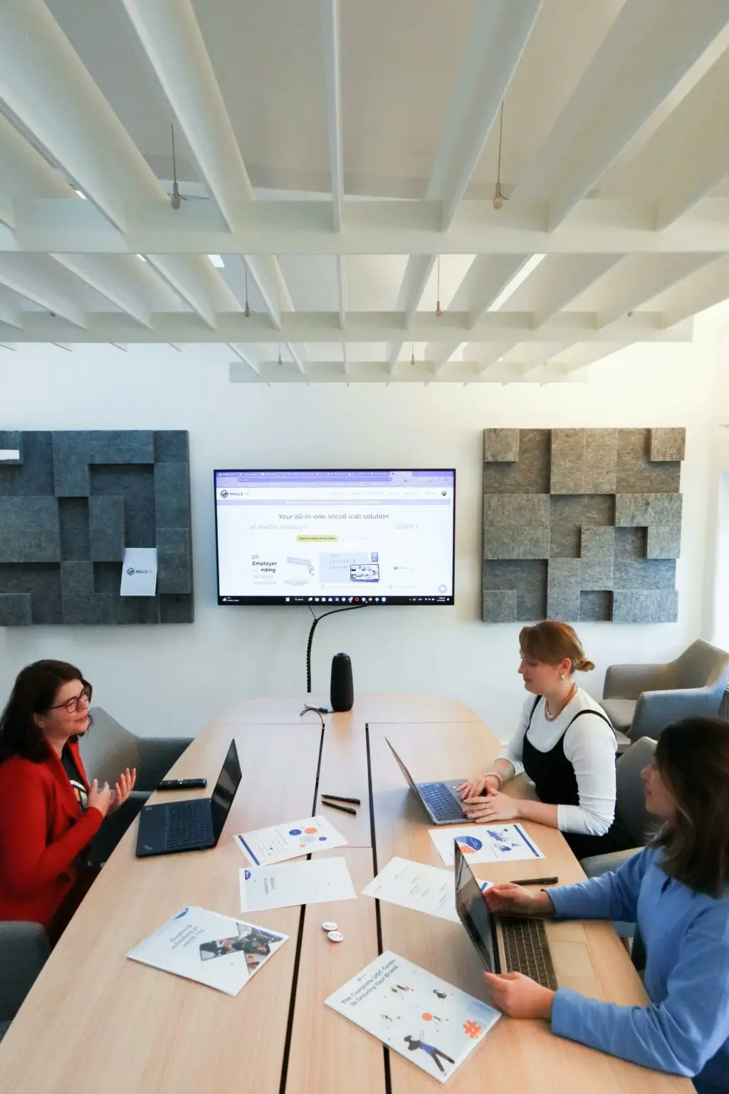 Women collaborating in a modern office, engaging in teamwork and technology discussions.